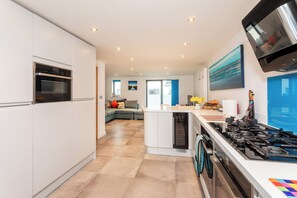 Una cocina moderna con electrodomésticos integrados, una isla central y una zona de comedor con vistas.
