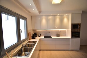 A modern kitchen with a built-in oven, a coffee maker, and a microwave. - Harmony Villa 2 (Karpathos)