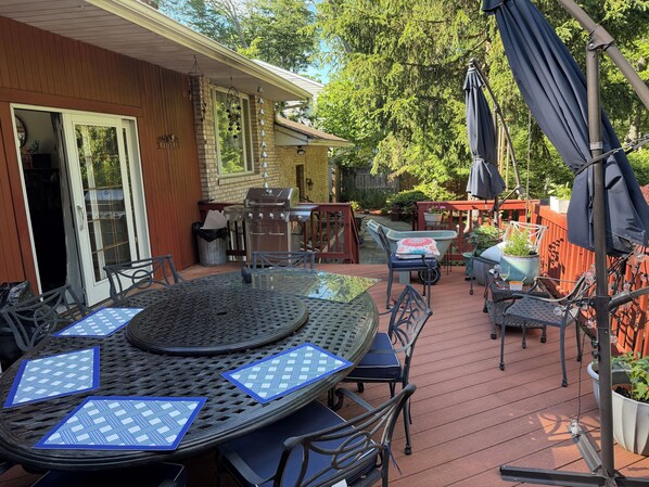 A patio with a round table, chairs, and umbrellas.