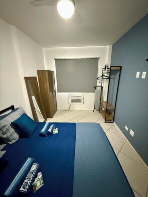 Ein Schlafzimmer mit einem Bett, einem Kleiderschrank, einem Spiegel und einer Heizung.