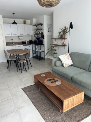 Un espacio habitable moderno con comedor, cocina y sofá.