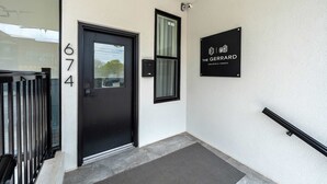 Une porte noire portant le numéro 674, une enseigne noire avec le logo « The Gerrard », et une main courante noire sur le côté droit.