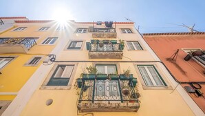 Un edificio de varios pisos con balcones, ventanas y un cielo despejado.