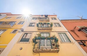 Ein mehrstöckiges Gebäude mit Balkonen und Fenstern vor blauem Himmel.