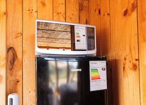 A refrigerator with a digital display and a microwave on top.