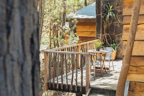 A wooden deck with a railing, a table, and chairs.