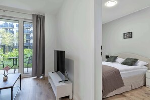 Ein Schlafzimmer mit Bett, Nachttisch und Fernseher auf einem Schrank.