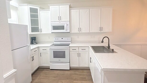A modern kitchen with white cabinetry, a microwave, an oven, and a sink. - Relaxing 2-Bedroom Condo with AC, WiFi in Scenic Canyon Lake (Canyon Lake)