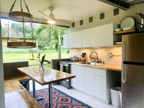 A modern kitchen with a gas stove, sink, and stainless steel refrigerator.