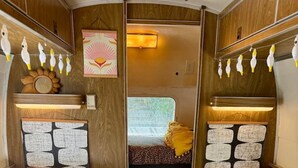 Ein gemütliches Interieur mit zwei Betten, einem Fenster und einer dekorativen Wand.