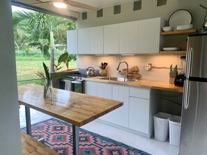 Eine moderne Küche mit weißen Schränken, einer Holzarbeitsplatte und einem Edelstahlkühlschrank.