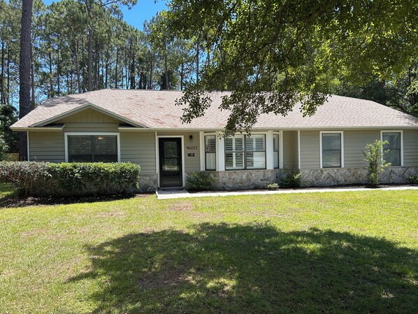 A single-story house with a stone foundation, a front door, and a garage. - Home with private pool near historic area and the beach in Fernandina Beach (Fernandina Beach)