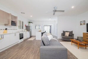 Ein modernes Apartment mit Küche, Wohnbereich und einem Balkon.