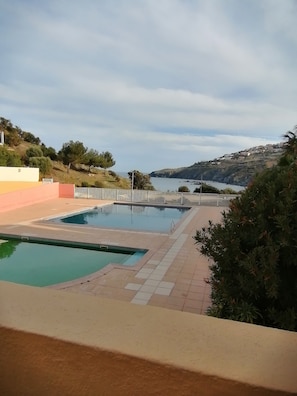 A swimming pool with a view of the sea and hills.