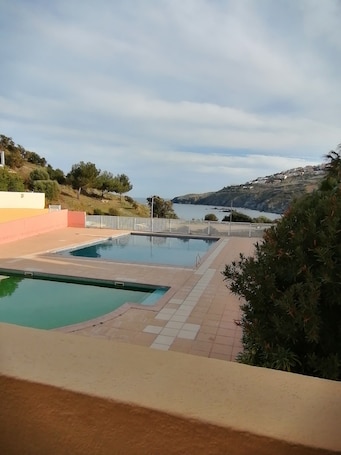 A swimming pool with a view of the sea and hills.. Holiday Home in 'Port Aloès' Resort with Sea View, Shared Pool and Air Conditioning