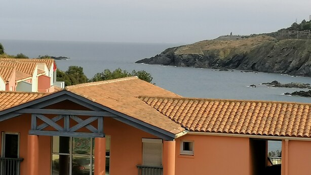 A coastal view with a building featuring a tiled roof and a small window. - Holiday Home in 'Port Aloès' Resort with Sea View, Shared Pool and Air Conditioning (Cerbère)