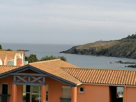 A coastal view with a building featuring a tiled roof and a small window.. Holiday Home in 'Port Aloès' Resort with Sea View, Shared Pool and Air Conditioning