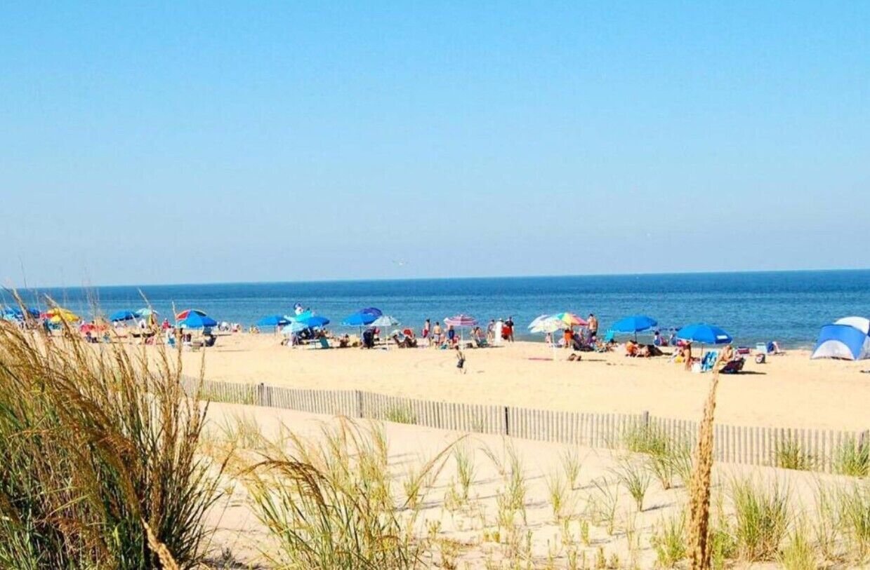 A beach with people, umbrellas, and tents.