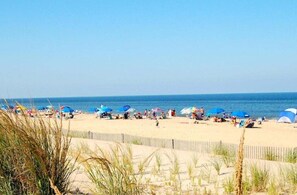 Ein Strand mit Menschen, Sonnenschirmen und Zelten.