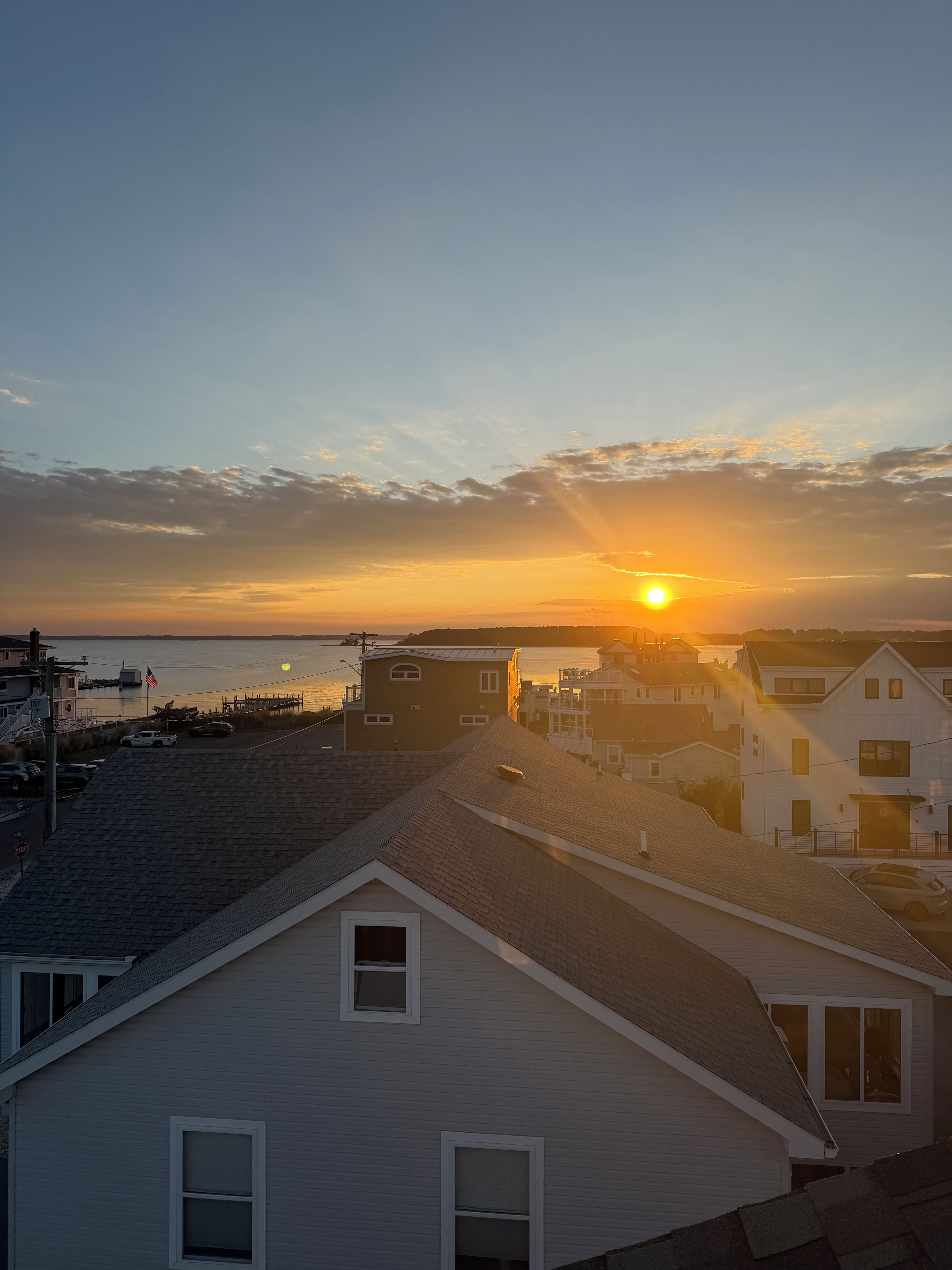 A residential area with houses and a pier, during sunset.