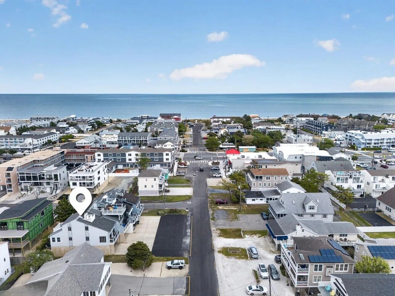 Una zona residencial costera con una avenida principal que conduce al mar, rodeada de casas y edificios.