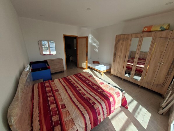 Une chambre à coucher avec un lit, une armoire, un bureau et une fenêtre.