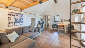 Una sala de estar acogedora con un sofá, una mesa de comedor y una zona de cocina al fondo.