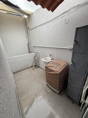 A small, enclosed bathroom with a toilet, sink, and shower area.