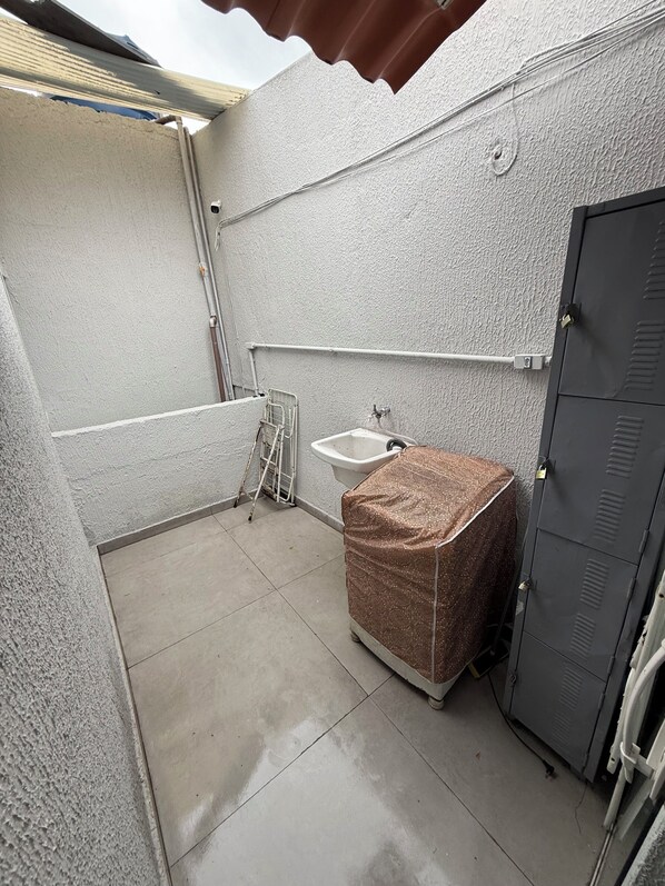 A small, enclosed bathroom with a toilet, sink, and shower area.