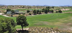 Un parcours de golf doté d’un club-house, d’un practice couvert et d’un étang.