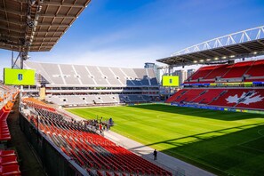 A stadium with tiered seating, a large field, and a distinctive roof structure. - The Gerrard Brand New Fifa Event Stay (Toronto)