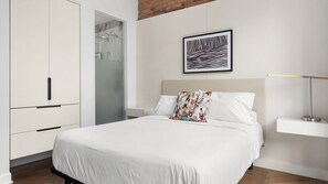 A bedroom with a bed, a wardrobe, a bedside table, and a framed picture on the wall. - Bowery Lofts Hotel Vieux Montreal (Montréal)