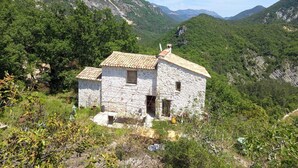A stone house with a tiled roof, surrounded by greenery and mountains. - Nature refuge in the Estéron valley, small authentic sheepfold, bohemian spirit (Sigale)