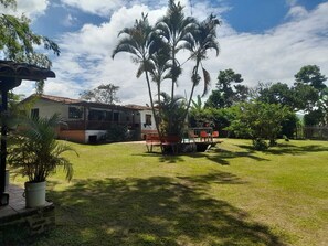 Una casa con patio cercado, piscina y palmeras.