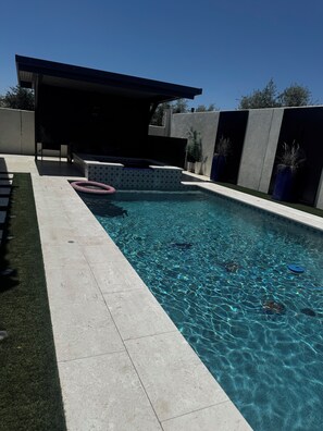 A rectangular swimming pool with clear water, surrounded by a tiled deck and a covered seating area. - Spacious 4 bedroom Retreat with Beautiful Pool in Glendale. Sleeps 10-12 (Glendale)
