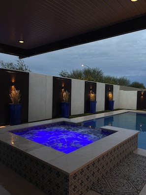 A modern outdoor pool area with a heated jacuzzi, potted plants, and a tiled deck. - Spacious 4 bedroom 4 bath Retreat with Beautiful Pool in Glendale. Sleeps 10-12 (Glendale)