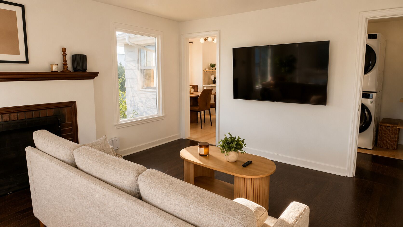 A living room with a sofa, a TV, a fireplace, and a dining area in the background.