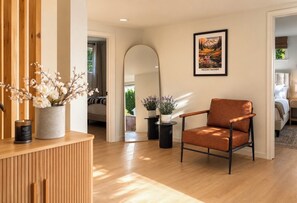 Een modern interieur met een houten receptiebalie, een bruine leren fauteuil en een lijst met een afbeelding van Mount Rainier.