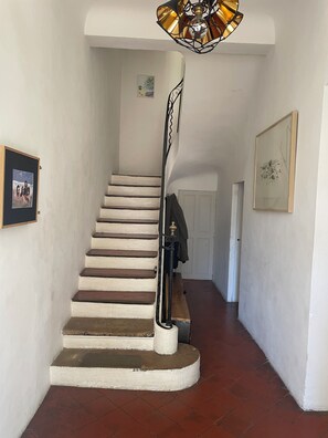 A staircase with a handrail, a picture frame on the wall, and a door at the end. - Character house with garden 10 minutes walk from the old town (aix en provence)