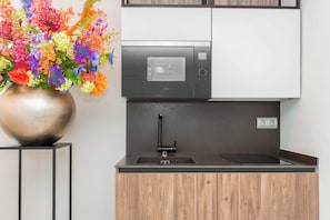 Eine moderne Küche mit eingebauter Mikrowelle, Spüle und Holzschränken.
