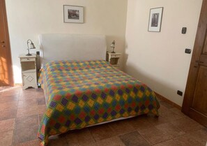 Een slaapkamer met een bed, twee nachtkastjes en een deur.