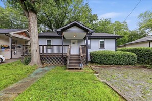 A single-story house with a front porch, a visible garage, and a well-maintained lawn. - 3BR Home | Minutes to World Cup & BeltLine (Atlanta)