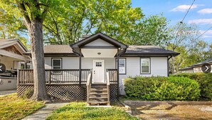 A single-story house with a front porch, a door, and a small staircase leading to the entrance. - 3BR Home Downtown Atlanta | BeltLine | Mozley Park (Atlanta)