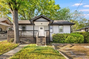 A single-story house with a front porch, a door, and a small staircase leading to the entrance. - 3BR Home | Minutes to World Cup & BeltLine (Atlanta)