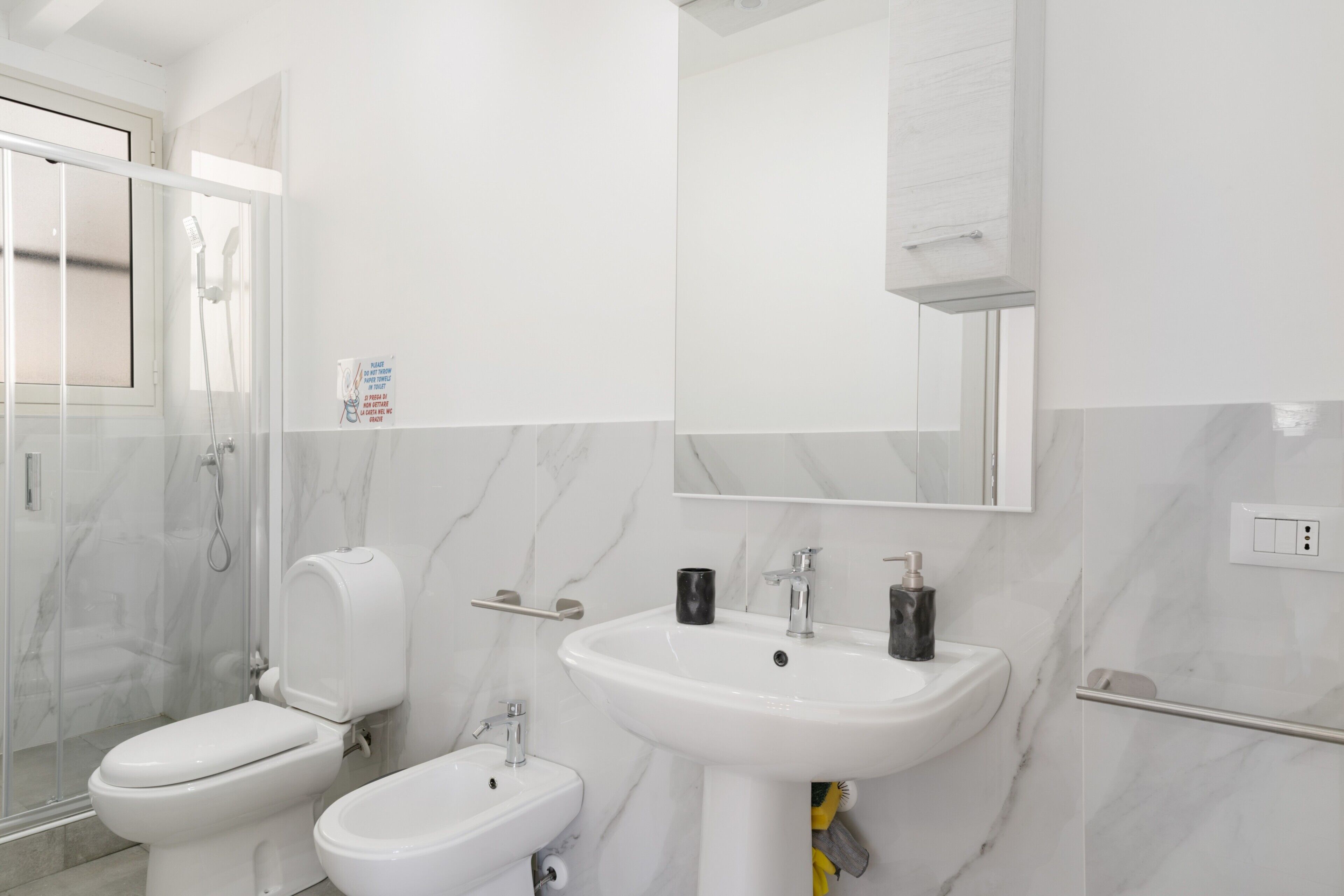 Une salle de bain moderne avec une douche à parois de verre, des toilettes, un bidet et un lavabo.