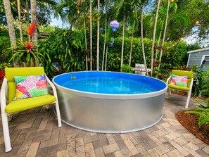An outdoor swimming pool with a hot tub, surrounded by lush greenery and two chairs with colorful cushions. - 12 Min to Beach - Karaoke Room, Pool & Games (North Miami Beach)