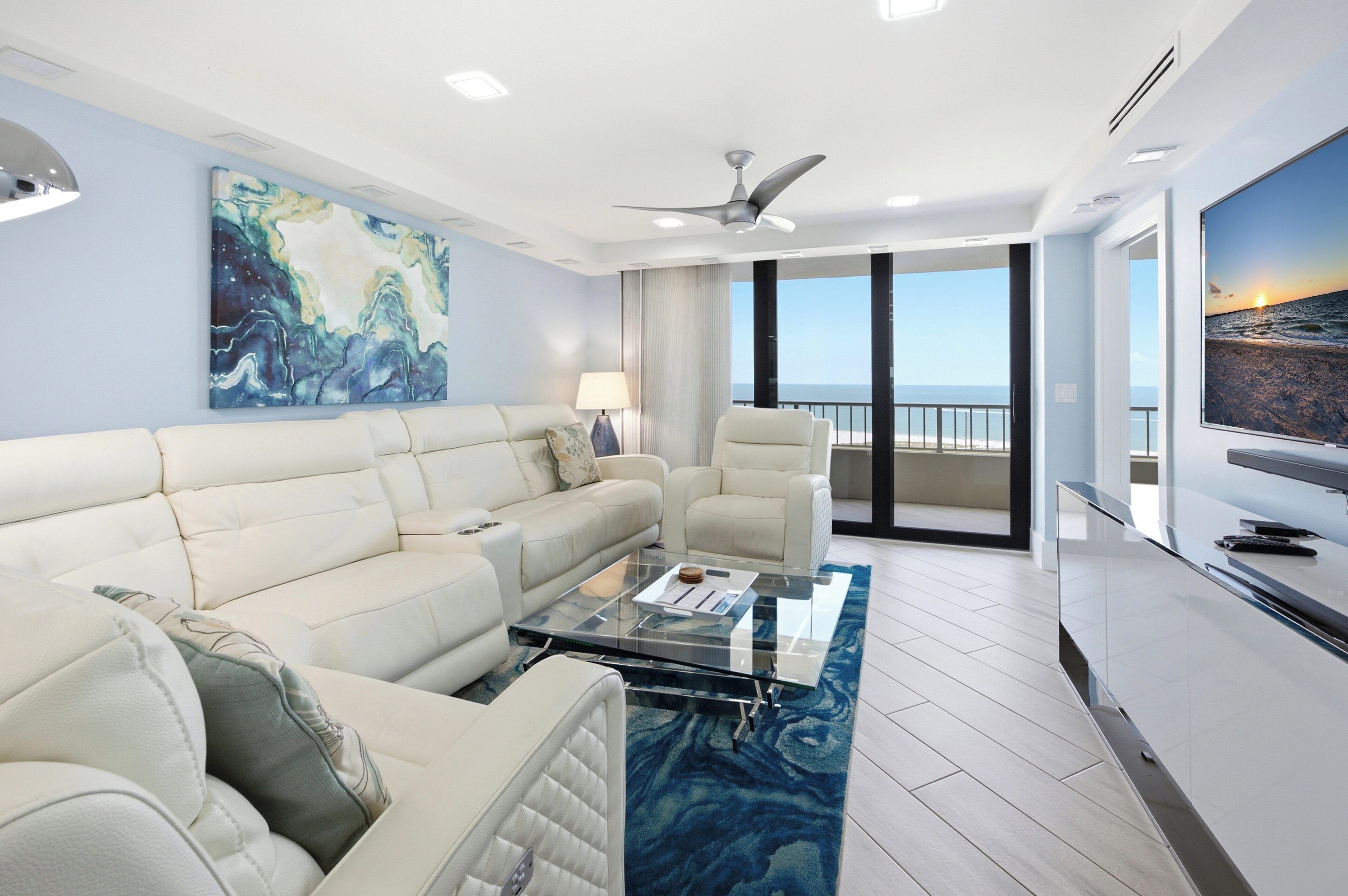 A modern living room with a sofa, armchairs, a coffee table, and a television.