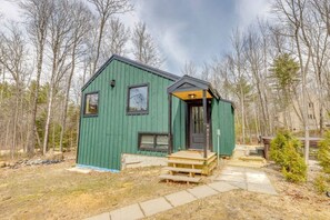 A small, green wooden cabin with a front porch and a single door. - Modern Mountain Retreat at Waterville Estates (Campton)