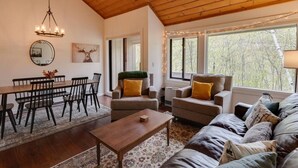 Ein gemütliches Wohnzimmer mit Essbereich, Holzboden und großen Fenstern.