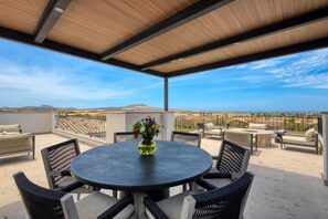 An outdoor patio with a round table, chairs, and a vase of flowers. - Luxury Coastal Retreat - Pool & World-class Golf (Cabo San Lucas)